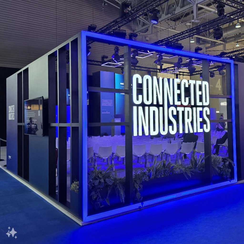 Connected Industries stage at MWC 2024 in Barcelona, lit in blue with presentation seating